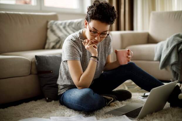 Serious person holding coffee mug and looking at document.