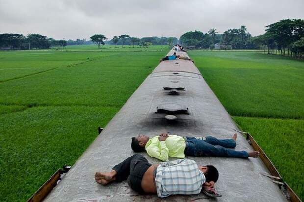 Привязанные к городу.  Под тяжелым небом сезона дождей, мигранты едут на поезде обратно в Дакку после посещения своих домов, которые находятся к северу от столицы. С другой стороны находятся рисовые поля, достаточно плодородные, но испорченные засоленностью на отдаленных южных территориях.