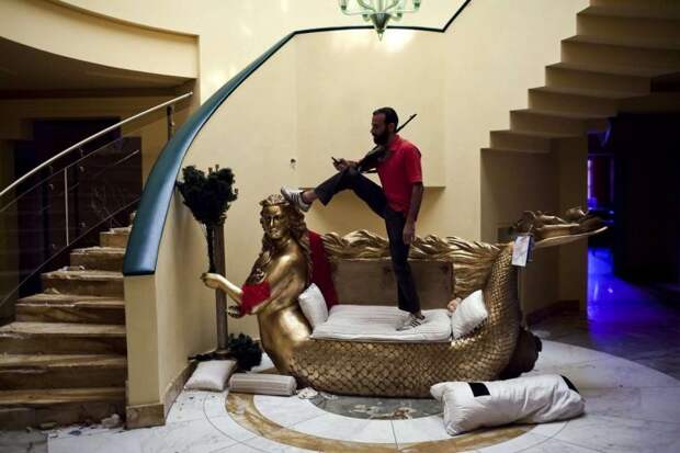 Этот диван в псевдоантичном стиле — образец роскоши во дворце ливийского лидера. Захватив резиденцию, повстанцы выместили на мебели свое отношение к недавнему правителю. Фото: Getty Images