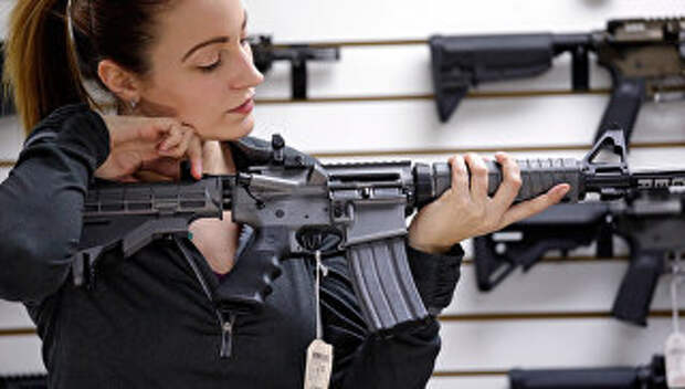 Девушка с автоматической винтовкой в магазине по продаже оружия в США. Архивное фото