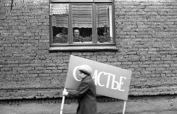 Женщина с плакатом спешит на первомайскую демонстрацию. СССР, Новокузнецк, 1 мая 1983 года. Женщина с плакатом спешит на первомайскую демонстрацию. СССР, Новокузнецк, 1 мая 1983 года.