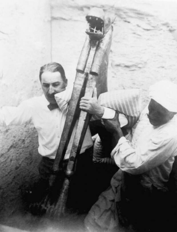 Археологи выносят древние артефакты во время раскопок в Каире.