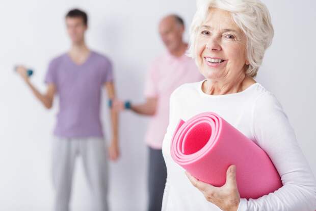 Happy elderly woman at gym alt