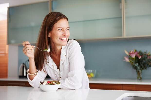 Woman having healthy breakfast and looking away with smile