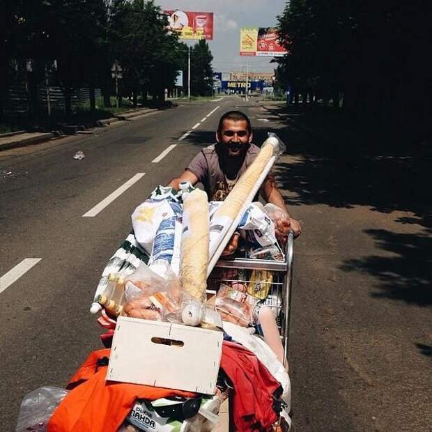 Думали закупился? Неееет. Мужик награбил в магазине "Метро" под Донецким аэропортом прилавки и тащит теперь это всё довольный домой. 27 мая 2014 года.