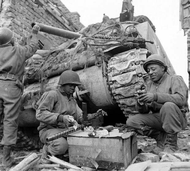 Танкисты американского 761-го танкового батальона во время обслуживания техники в перерыве между боями. Батальон был укомплектован неграми. 1945 год. Германия.  история, ретро, фото