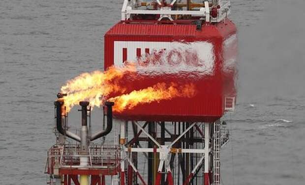 A gas torch is seen next to the Lukoil company sign at the Filanovskogo oil platform in the Caspian Sea, Russia October 16, 2018. Picture taken October 16, 2018. REUTERS/Maxim Shemetov