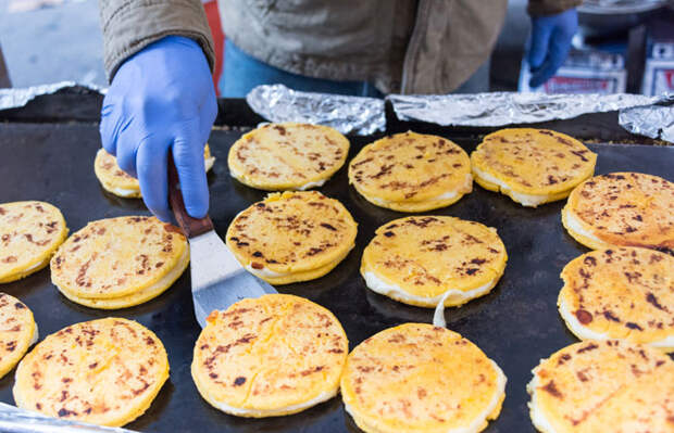 Свежие колумбийские арепас с сыром готовятся на гриле