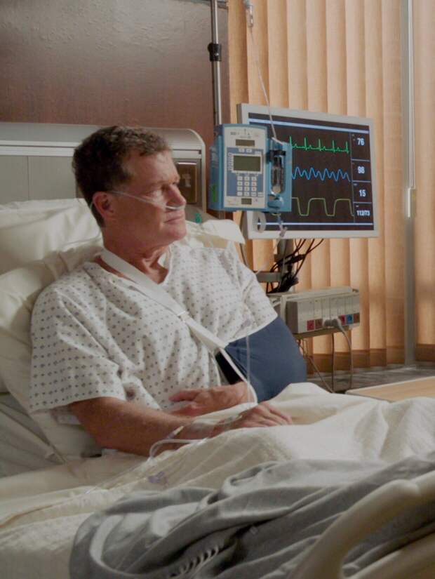 Frank visiting an injured Chase, who is in a sling and oxygen mask, in the hospital on Blue Bloods Season 14 Episode 18