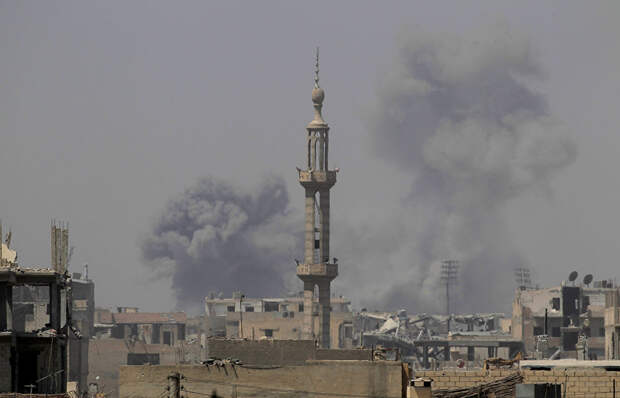 Дым после авиаудара в Ракке, Сирия