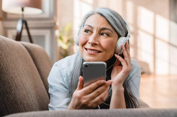 Person with headphones listening on phone.