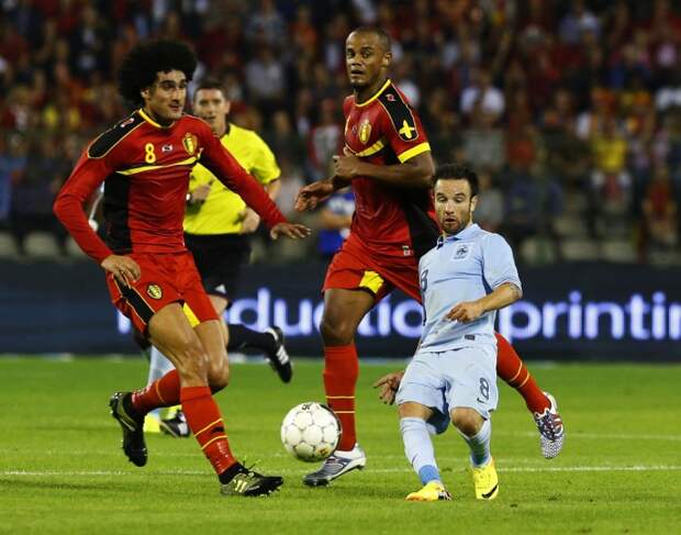 France's Mathieu Valbuena, right, is challenged by Belgium's Marouane Fellaini, left, and Vincent Kompany during their international friendly soccer match at the King Baudouin stadium in Brussels on August 14, 2013. (REUTERS / Yves Herman)