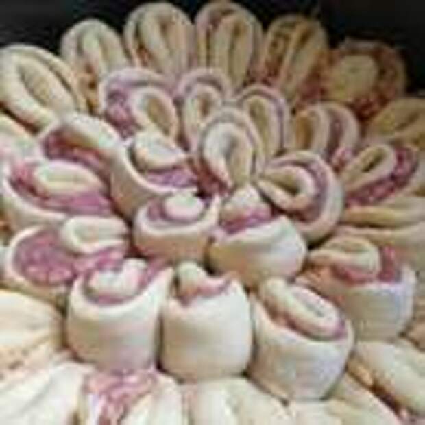 Разъемную форму 28 см выстелить пергаментом и смазать маслом. Плотно выложить в нее все лепестки. Когда закончится 1-я часть теста, со 2-й поступить аналогично. 