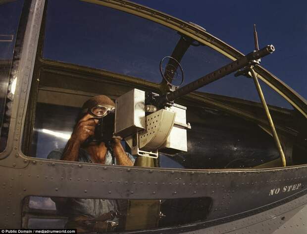 Jesse Rhodes Waller, A.O.M., third class, tries out a 30-caliber machine gun he has just installed in a Navy plane