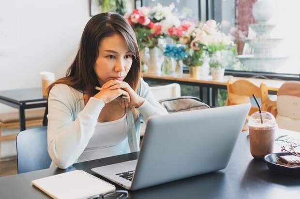 A person at a laptop with a serious expression.