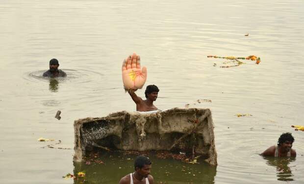 A man holds the hand of an idol of the Hindu elephant god Ganesh, the deity of prosperity, during idol immersion ceremony in the Hussain Sagar lake during the Ganesh Chaturthi festival in the southern Indian city of Hyderabad on September 17, 2013. (REUTERS / Krishnendu Halder)