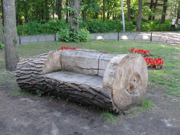 Скамейка в парке, высеченная из ствола старого дерева. Скамейка в парке, высеченная из ствола старого дерева.