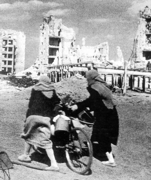 Две жительницы Сталинграда везут на велосипеде свои вещи, покидая город. Две жительницы Сталинграда везут на велосипеде свои вещи, покидая город.