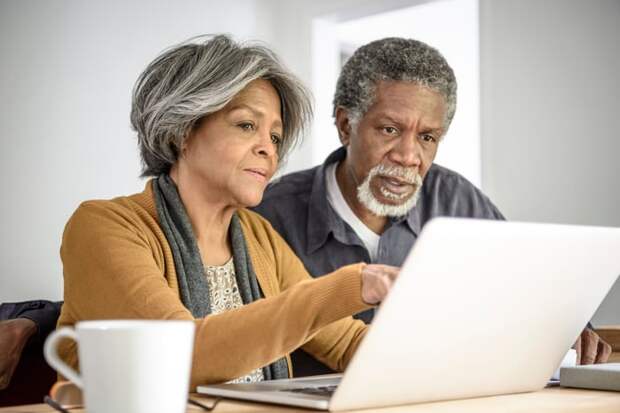 Two people looking at laptop.