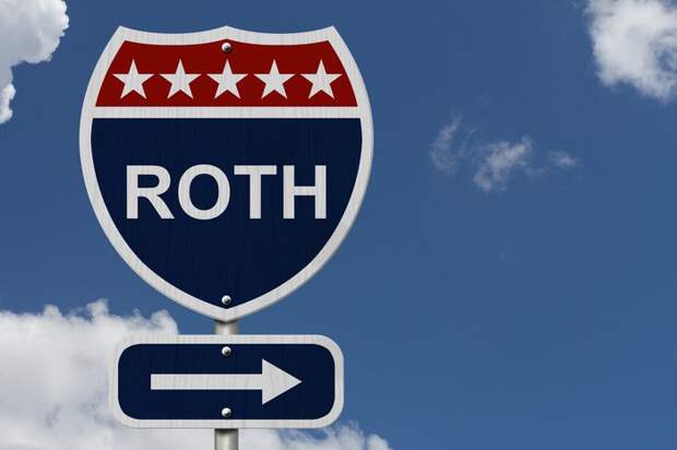 Road sign saying Roth with arrow pointing to right, against a blue sky backdrop.