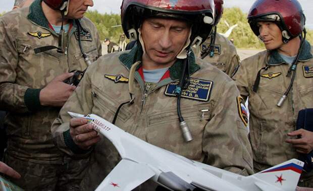 Президент России Владимир Путин держит макет стратегического бомбардировщика Ту-160
