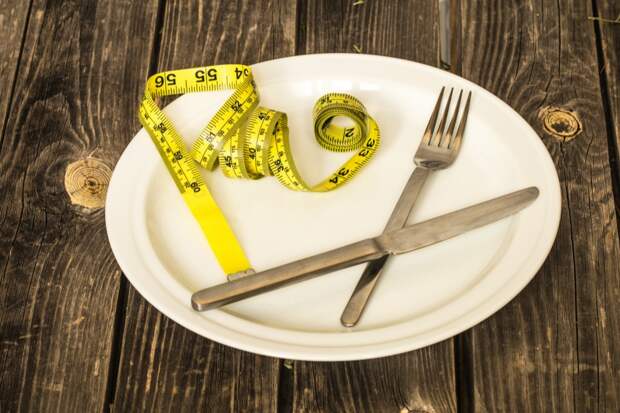 white-plate-with-bun-yellow-tape-measure-cutlery-table Жесткие диеты: последствия для здоровья
