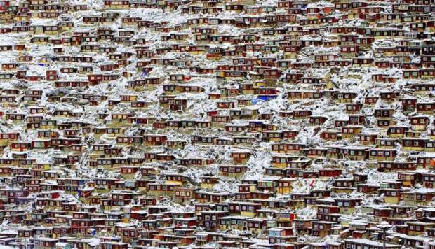 Красные дома лам и монахинь покрыты обильным снежным покровом. Автор фотографии: Кингджин Рон (Qingjun Rong).
