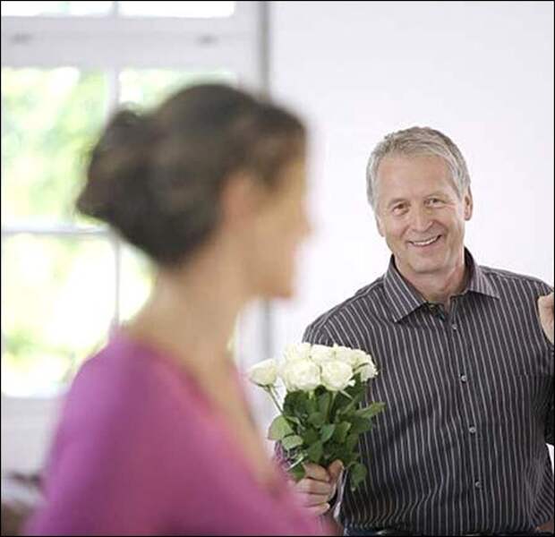 mature_man_holding_white_roses_for_woman_20294