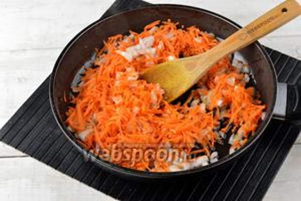 Тем временем 1 морковь очистить и натереть на тёрке с крупными отверстиями. 1 луковицу очистить и порезать мелким кубиком. Выложить морковь и лук в сковороду с подсолнечным маслом (2 ст. л.).