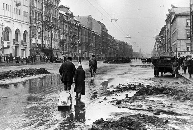Жители блокадного Ленинграда везут на санках тело умершего, 1942 год