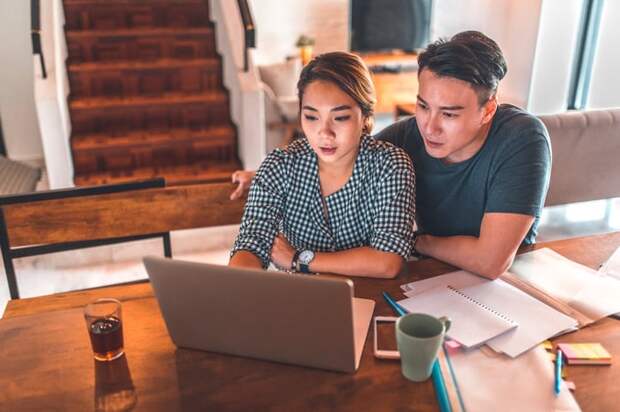 Two people looking at laptop together.