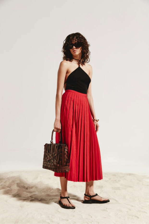 Боди Bottega Veneta, юбка Valentino, сумка Jil Sander, сандалии Gia Couture, очки Balenciaga, браслет Loewe