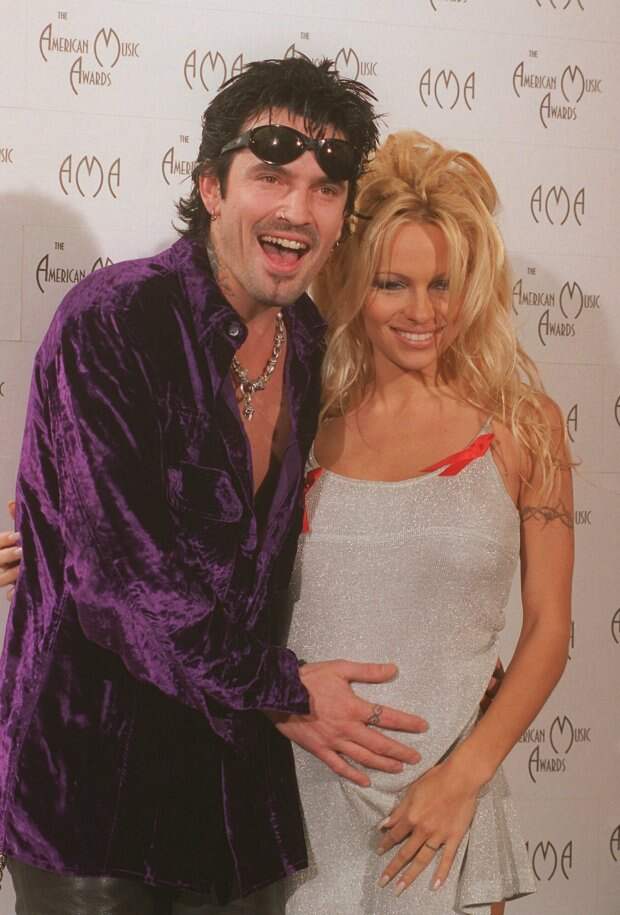 Rock singer Tommy Lee places his hand near the stomach of his pregnant wife Pamela Lee during the 23rd annual American Music Awards at the Shrine Auditorium in Los Angeles, Monday, Jan. 29, 1996. The couple were presenters during the award show. (AP Photo/Mark J. Terrill)