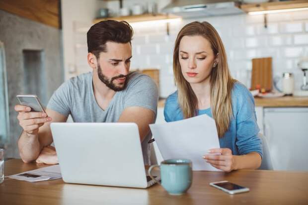 Couple reviewing finances in kitchen. 