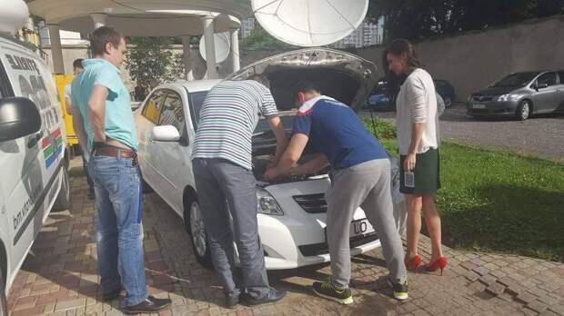 вполне нормальная ситуация. мужчины помогают женщине с автомобилем