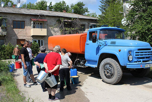Жители города Старый Крым набирают в емкости питьевую воду, привезенную в цистернах