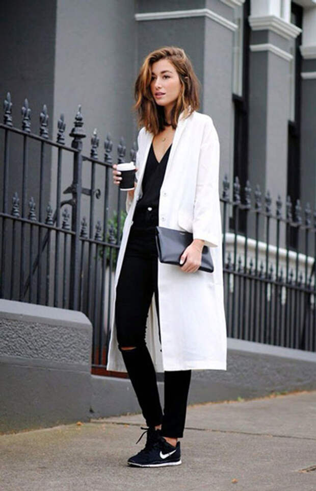 Девушка в белом пальто и черных джинсах