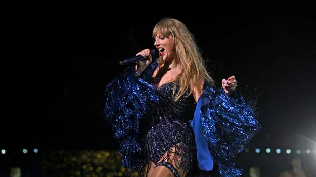 Taylor Swift eras tour on stage in a blue and black dress