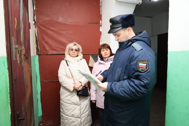 Судебный пристав и возмущённые жительницы подъезда. Фото: Григорий Матвеев