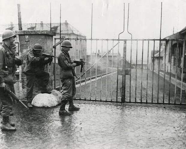 Американские солдаты расстреливают замки ворот немецкого лагеря военнопленных в Хаммельбурге. 6 апреля 1945 года. история, факты, фото