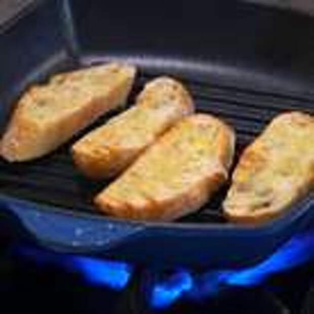 Разогреть сковороду гриль и обжаривать хлеб с двух сторон до появления румяной корочки, затем натереть оставшимся зубчиком чеснока.