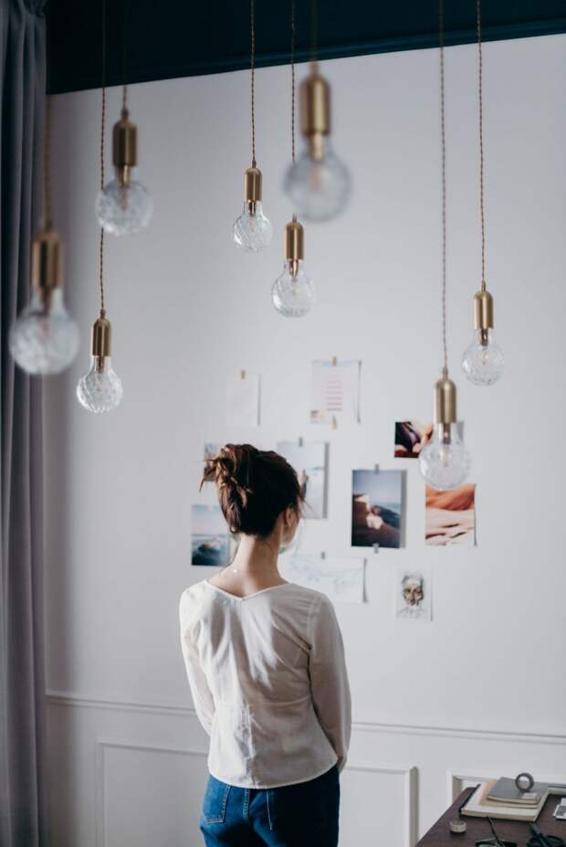 woman-under-pendant-lights-looking-at-the-photo-on-the-wall-3584992-1080x1616