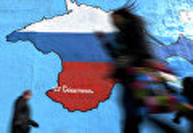 Прохожие у нарисованной на стене карты Крыма в цветах российского флага в Москве