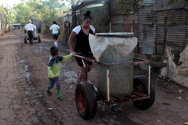 Люди толкают телеги с водой из колодца к себе по домам на окраине Манагуа