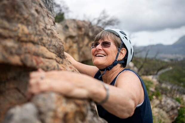 Smiling person rock climbing.