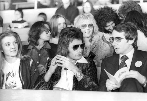 VARIOUS QUEEN MARY AUSTIN, FREDDIE MERCURY'S GIRLFRIEND (1ST L) FREDDIE MERCURY AND MANAGER JOHN REID (C) ALSO 3RD L (BACK ROW) CHRISSIE MULLEN MAY, BRIAN MAY'S WIFE, ALSO 5TH L ROGER TAYLOR AT KEMPTON PARK FOR THE RELEASE OF 'DAY AT THE RACES'. ROGER TAYLOR AND BRIAN MAY WITH FANS - OCT 1976