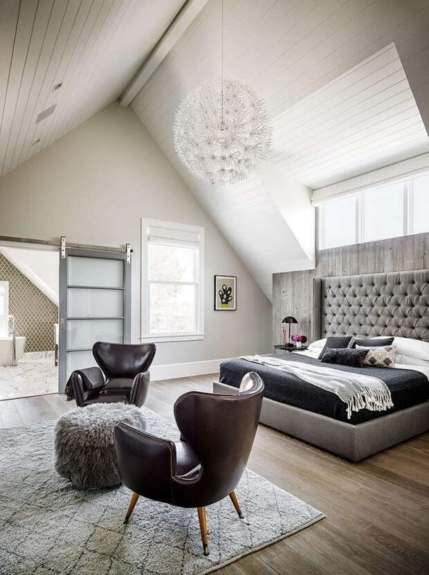 Уютная современная спальня с просторной кроватью и шикарными кжаными креслами