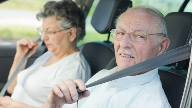 Elderly couple putting on their seatbelts