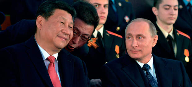 Председатель КНР Си Цзиньпин (слева) и президент РФ Владимир Путин оживленно беседовали, наблюдая военный парад на Красной площади 9 мая