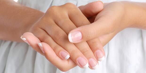 Girl hands on the white dress background, close-up